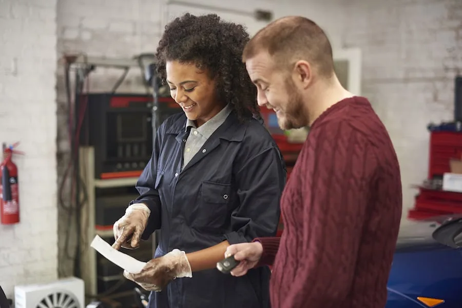 female mechanic explains bill to customer