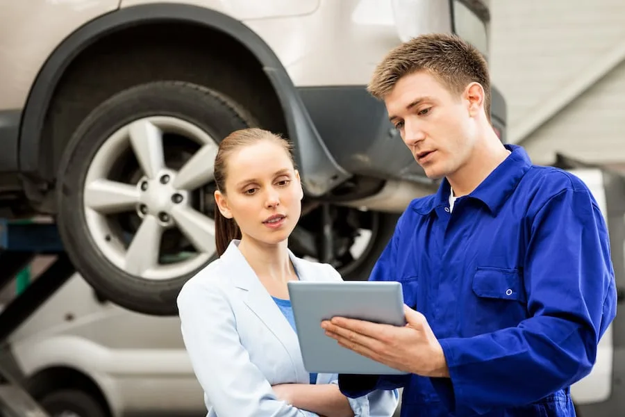 Mechanic With Customer Using Digital Tablet